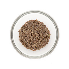 Top view of Organic Caraway (Carum carvi) half filled in glass bowl isolated on white background.