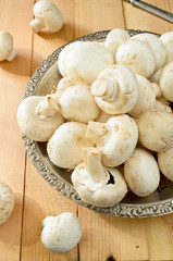 raw champignons on wooden background
