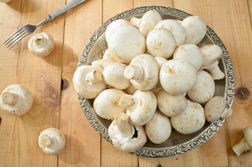 raw champignons on wooden background