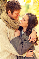 Fototapeta premium smiling couple hugging in autumn park