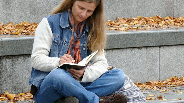 a woman writing in a book
