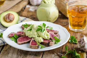 Beef steak with avocado dip and herbs