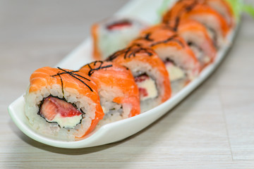 Close-up of a white plate with sushi set -  salmon with strawber