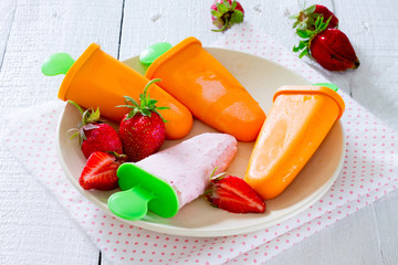 Homemade popsicles in a bowl on a wooden table