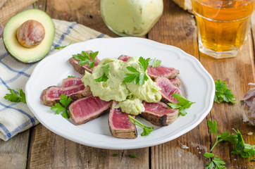 Beef steak with avocado dip and herbs