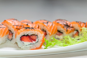 Close-up of a white plate with sushi set -  salmon with strawber