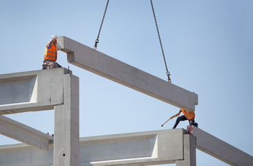 Height workers placing truss on building skeleton