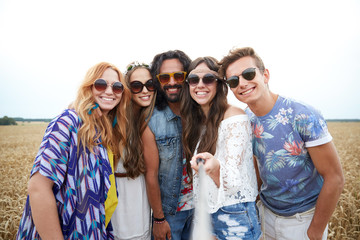 Fototapeta premium smiling young hippie friends on cereal field