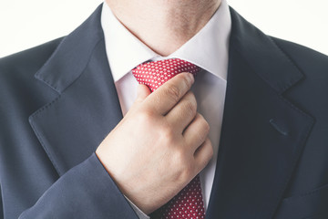 hombre de negocios abrochándose la corbata - obrazy, fototapety, plakaty