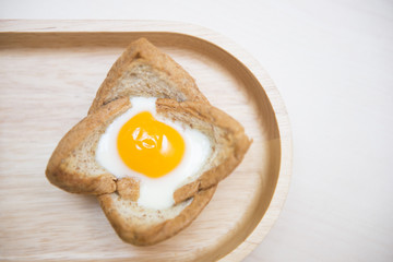 baked egg in bread bowl on wooden tray