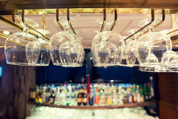 Empty wine glasses on the bar rack, Vintage filter.