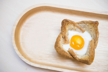 baked egg in bread bowl on wooden tray