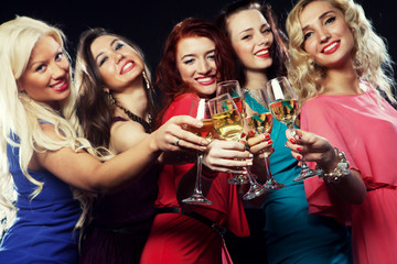partying girls clinking flutes with sparkling wine