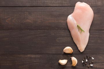 Top view raw chicken breast and garlic, pepper on wooden backgro