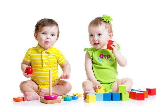 Two adorable kids playing with toys. Toddlers girl and boy