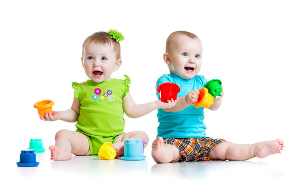 Adorable babies playing with color toys. Children girl and boy