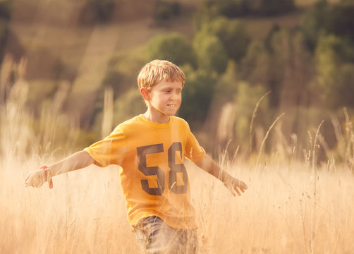 Boy run on sunny field
