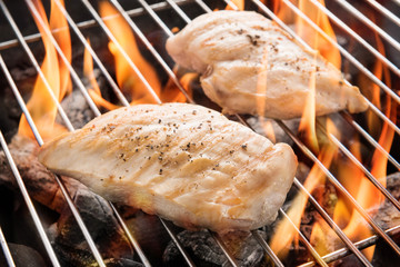 Grilled chicken breast on the flaming grill