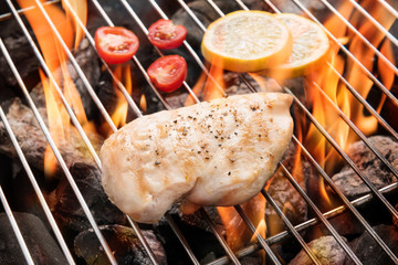 Grilled chicken breast on the flaming grill