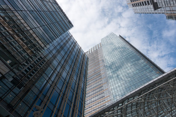 Fototapeta na wymiar 青空と雲を反射する高層ビル群と商業施設