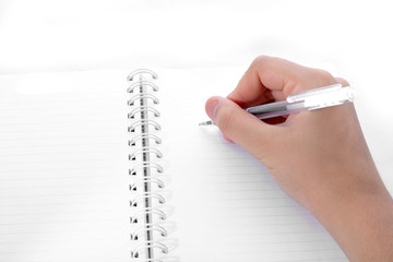 hand with pen writing in notebook