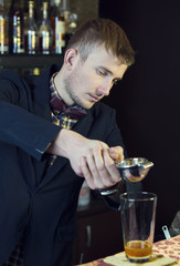young man working as a bartender in a nightclub bar