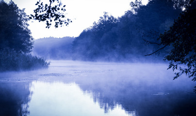 Blue morning fog on a calm river