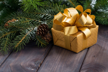 Fototapeta na wymiar golden gift box on the background of fir branches