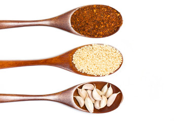 Sesame seeds on wooden spoon isolated on white background.