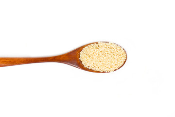 Sesame seeds on wooden spoon isolated on white background.