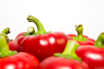 Many ripe red peppers on over white