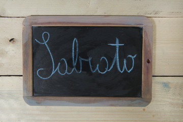 Fototapeta premium lavagna con scritta sabato su sfondo di legno