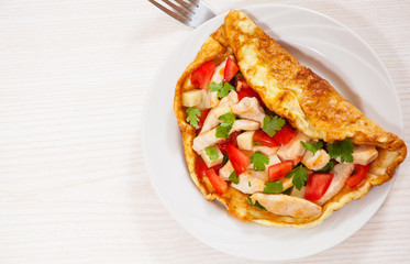 omelette with slices of chicken breast, cheese and vegetables