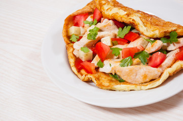 omelette with slices of chicken breast, cheese and vegetables