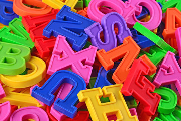 Fototapeta premium Heap of plastic colored alphabet letters close up