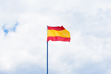 Spanish flag in cloudy sky