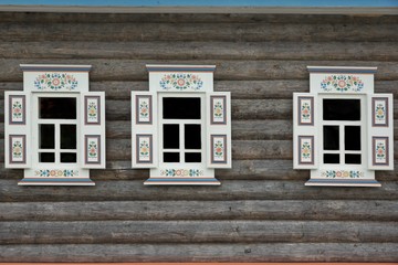 Log Cabin Wall With Three Ornamental Windows