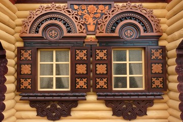 Yellow Log Cabin Wall With Two Ornamental Windows