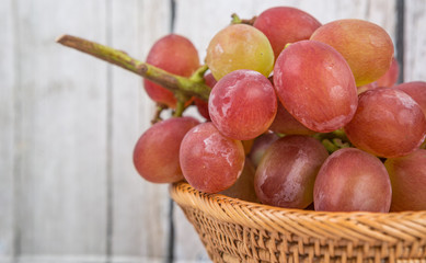 A bunch of fresh red grapes over wooden background