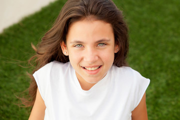 Casual teenager girl sitting on the grass