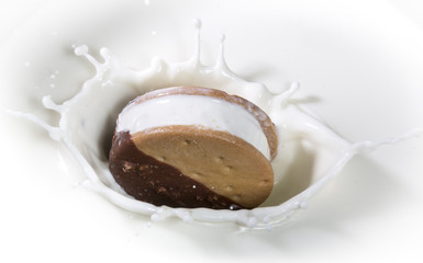 Biscotto ripieno di gelato tuffato nel latte