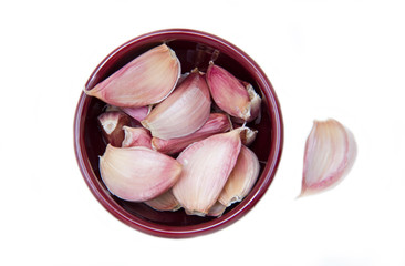 Cloves of garlic on bowl on white background seen from above