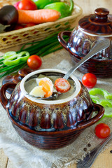 Vegetables baked in a pot on a wooden background