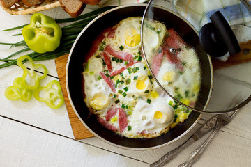 Fried eggs with fried sausage slices, top view