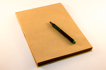 brown paper notebook with pen