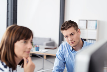 Obraz premium zwei kollegen schauen konzentriert auf den computer-bildschirm