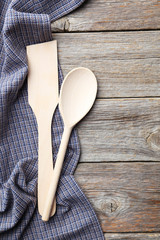 Empty wooden table with wooden spoon and napkin on grey backgrou