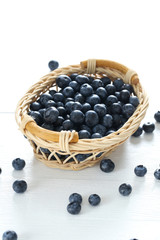 Blueberries in basket on a blue wooden background