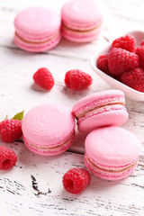 Raspberry macarons on white wooden background