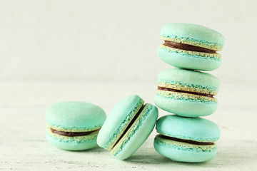 Green macarons on white wooden background